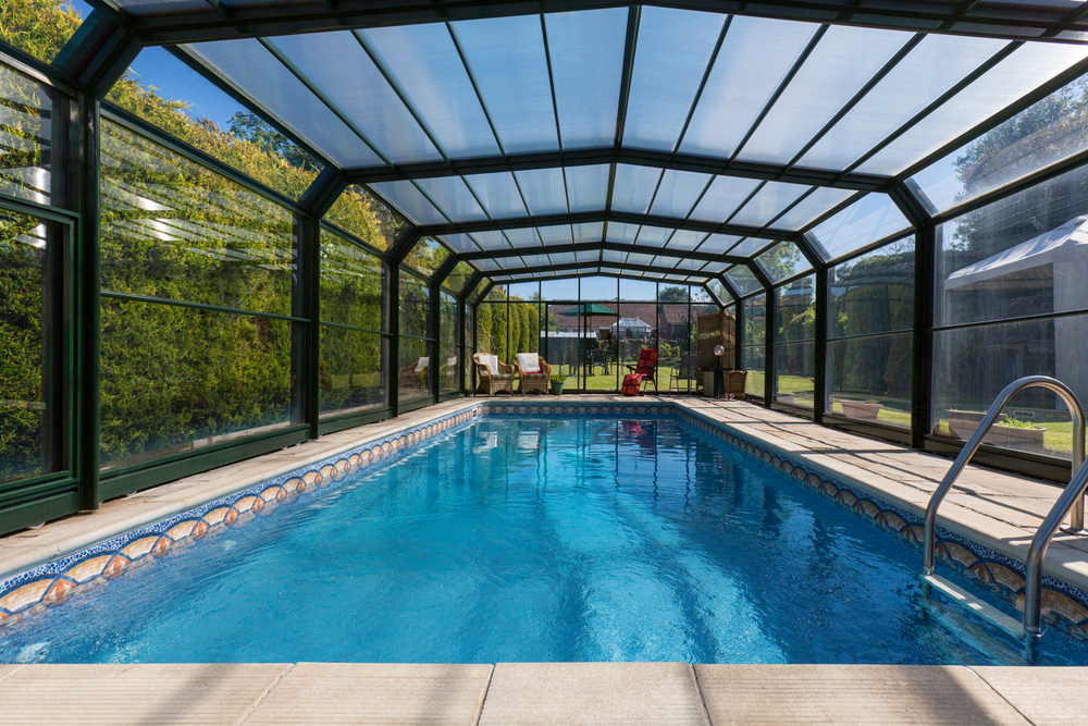 Véranda en verre sur une piscine.